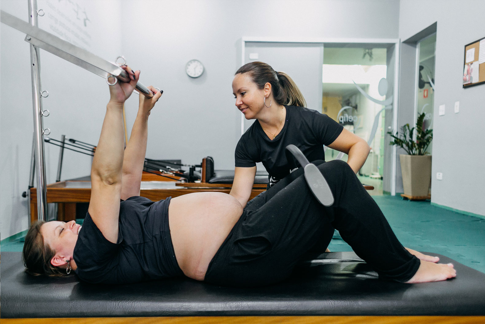 Pilates para gestante no cadillac, com a marca CEFIP na porta de vidro